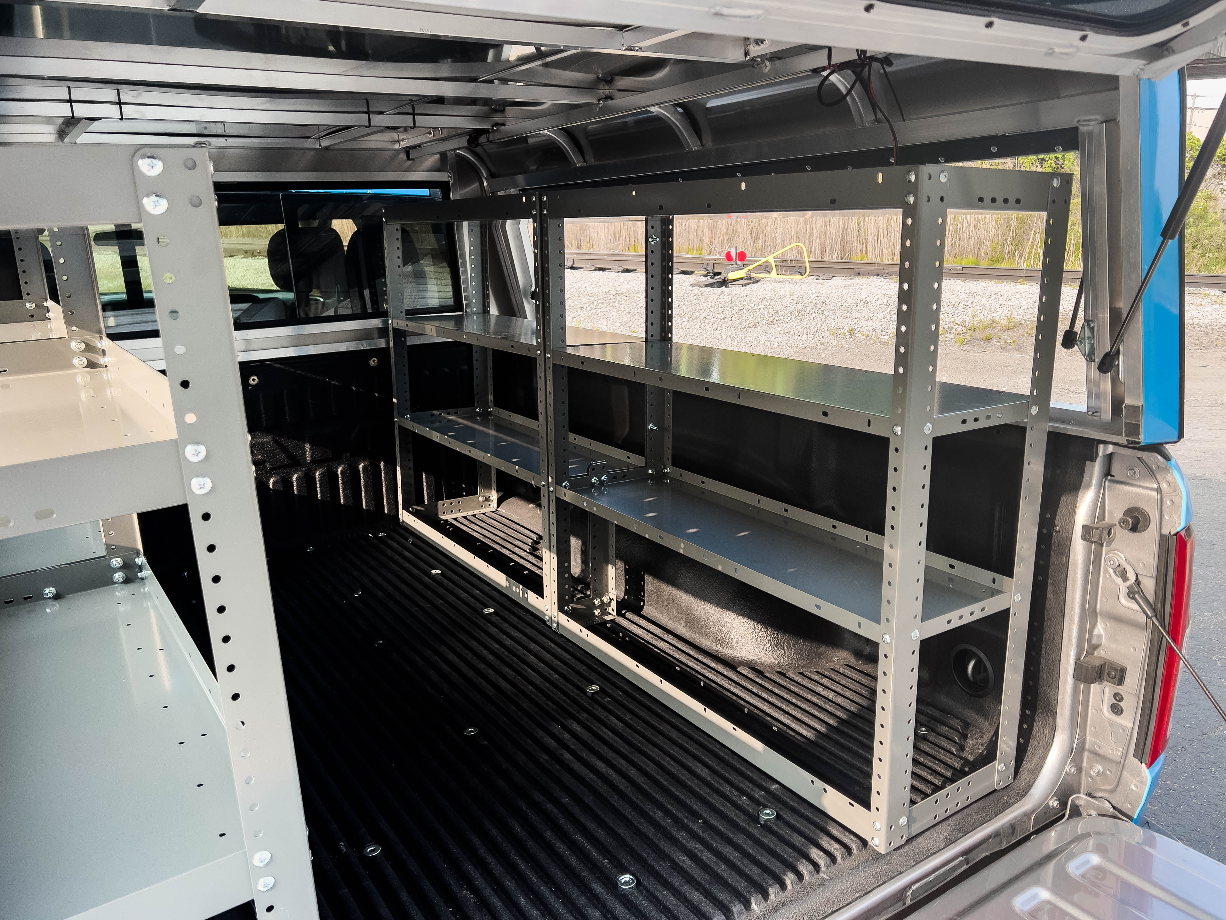 two empty shelves on the bed of a pickup upfitted with an Adrian Steel Base truck storage package