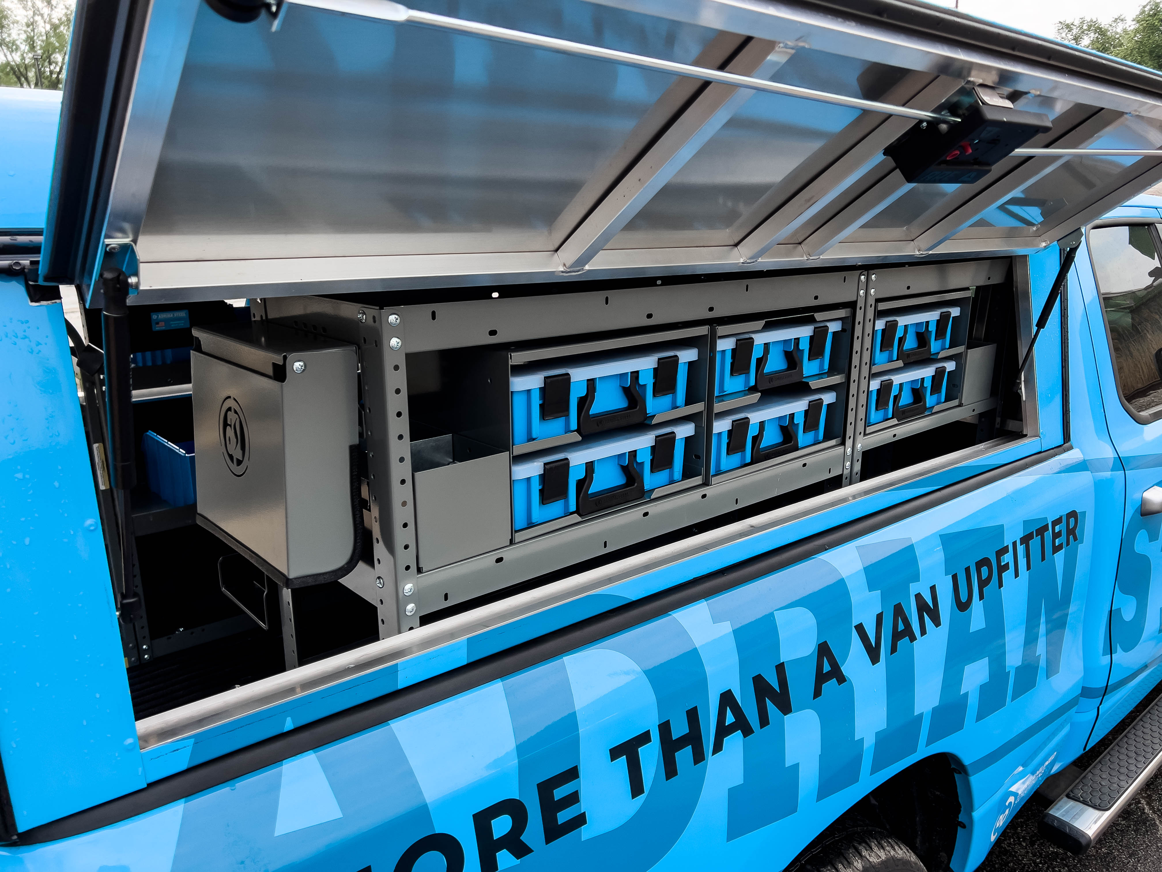 exterior view of two shelves containing some portable parts cases in a pickup upfitted with an Adrian Steel HVAC package