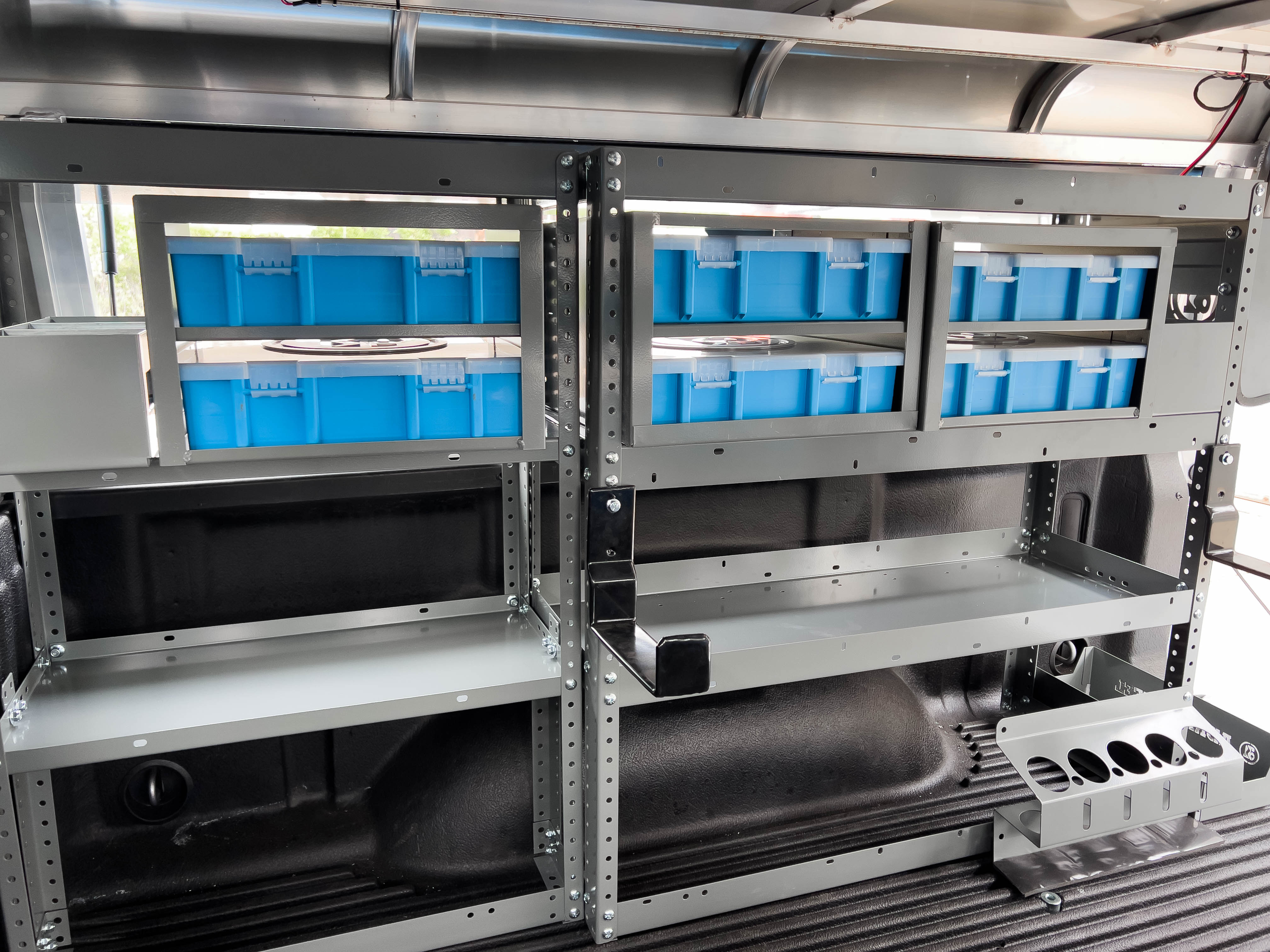 front view of two shelves with some portable parts cases in a truck upfitted with an Adrian Steel HVAC storage package
