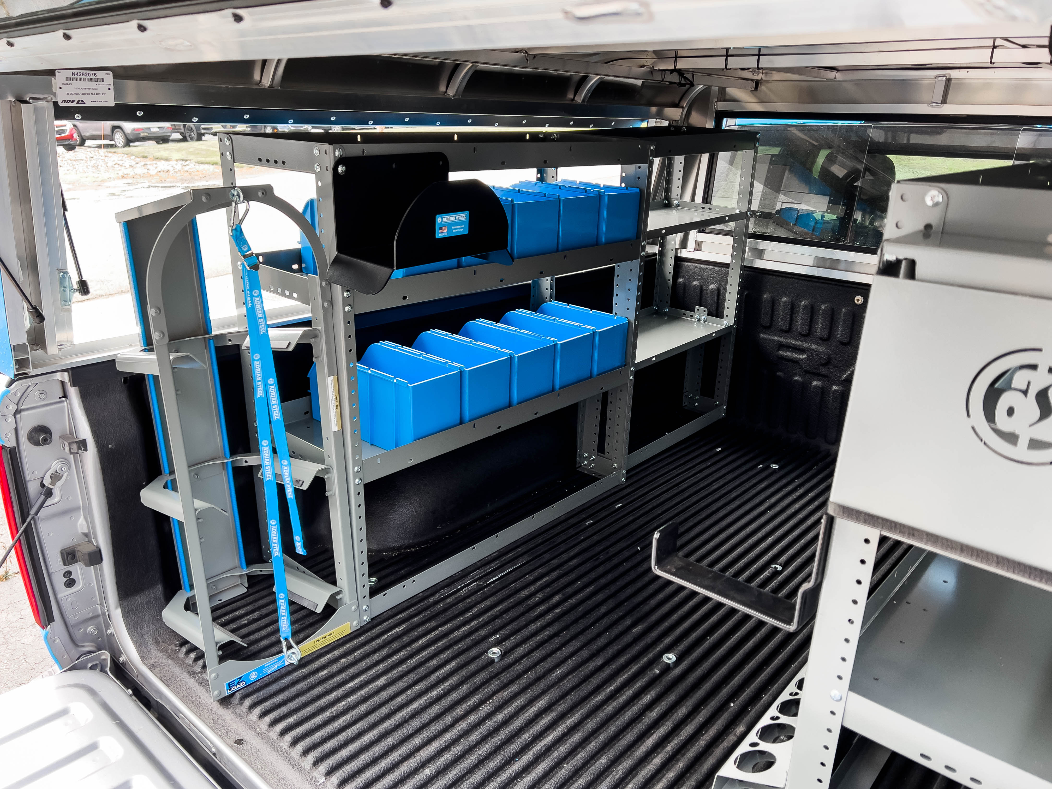 tank storage and a few shelves containing several portable bins in a pickup upfitted with an Adrian Steel HVAC truck package