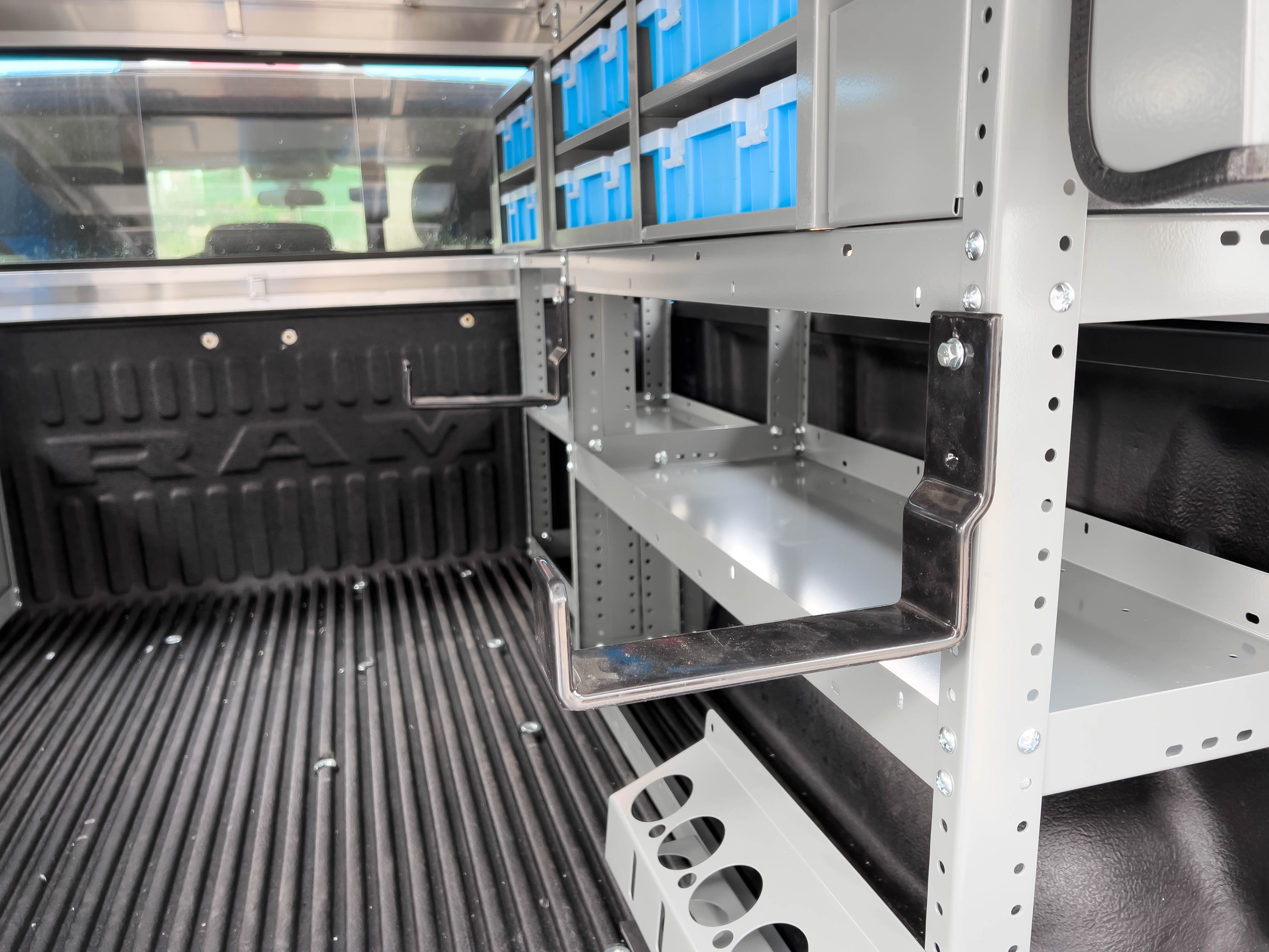 two hooks mounted on a shelf in a pickup upfitted with an Adrian Steel HVAC/Mechanical truck storage package