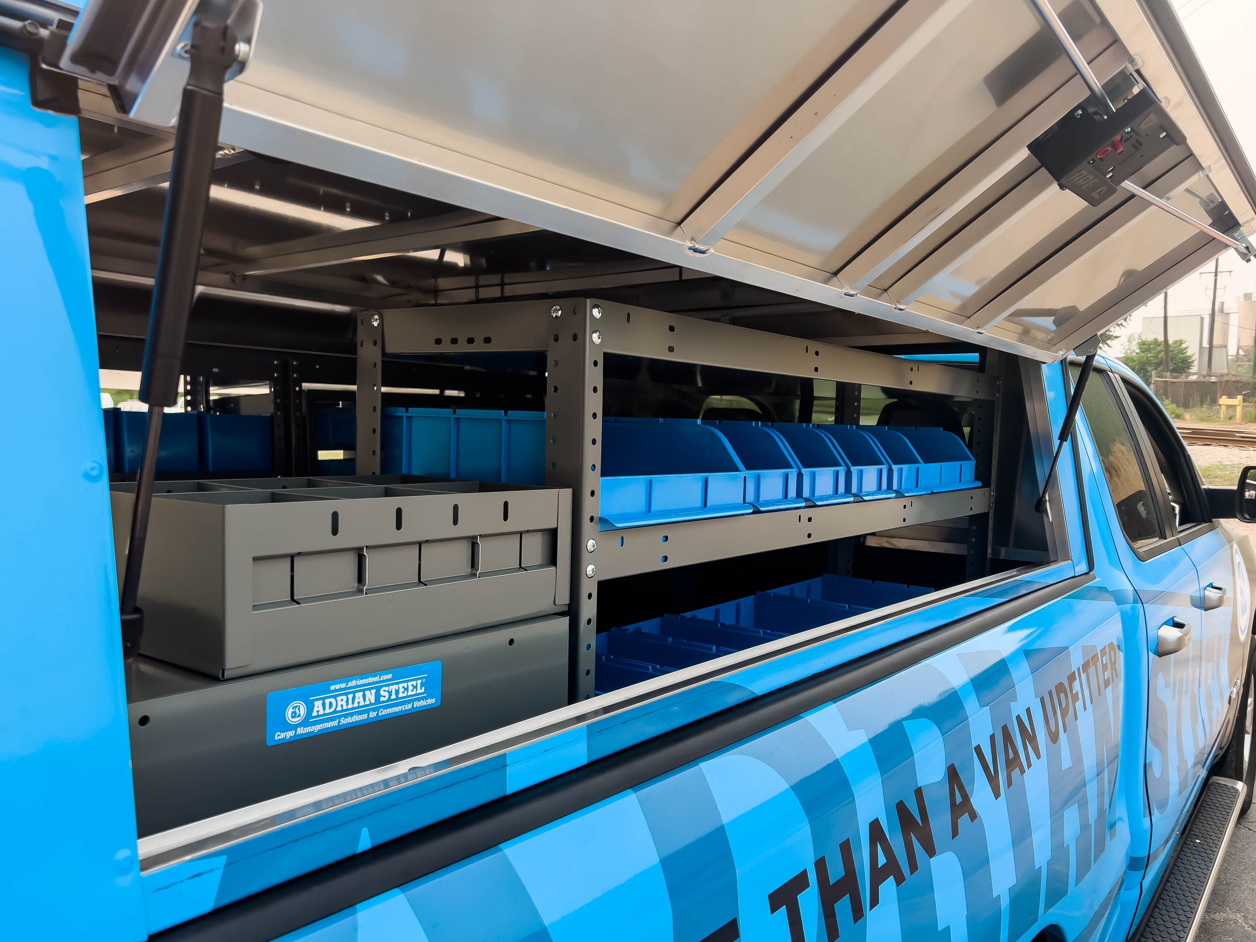 exterior view of a shelf full of portable bins in a pickup upfitted with an Adrian Steel Security Contractor storage package