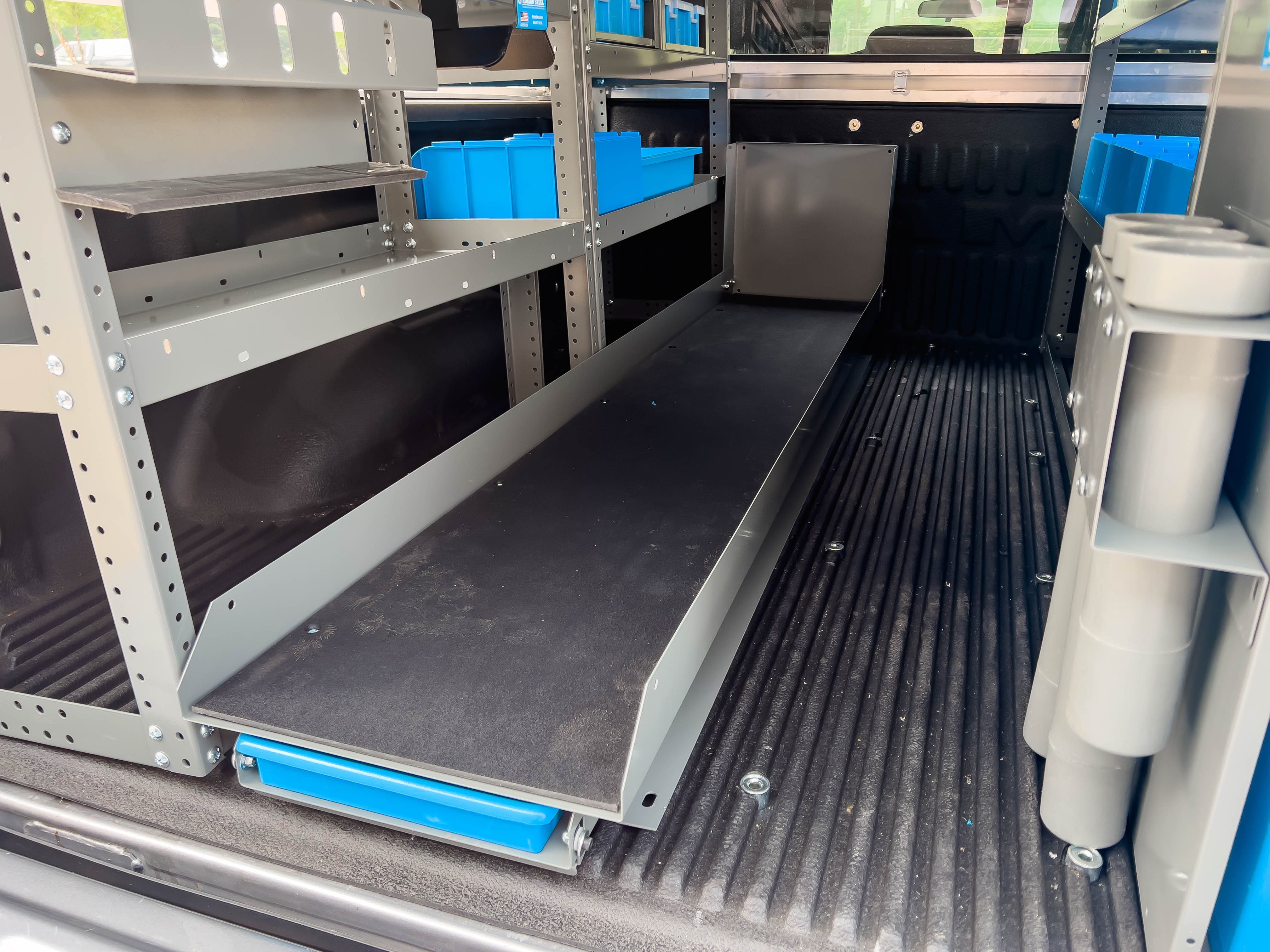 a ladder shelf/drill bit storage on the bed of a pickup upfitted with an Adrian Steel Security Contractor storage package