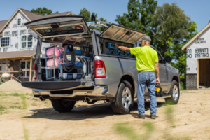 A man standing beside his work truck featuring many trade upfits to improve efficiency