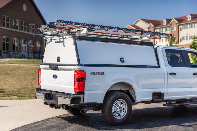 White work truck with topper and ladder rack