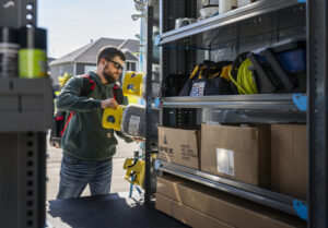 Technician getting tools out of the back of a van organized with a cargo management system