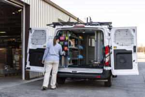 electrician standing next to an organized upfitted van.
