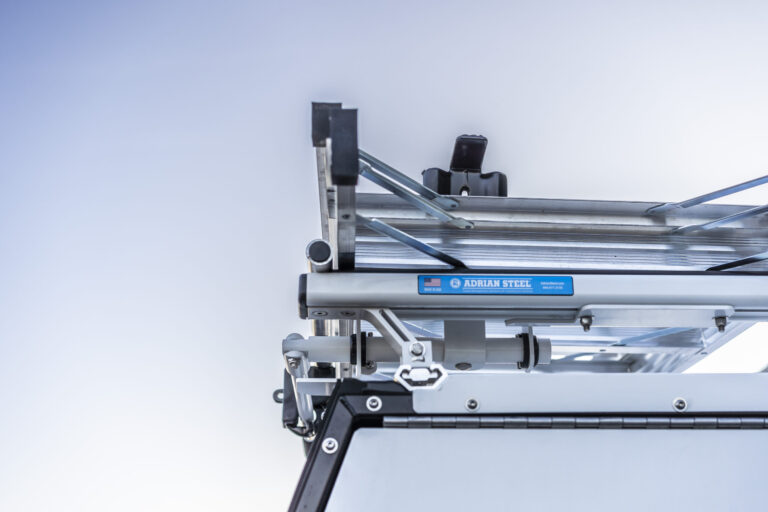 Angled view that shows the top of a work truck with a load runner rack and ladder attached.