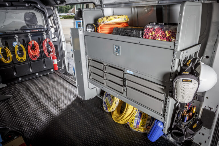 The inside of a van upfitted with a drawer storage system.