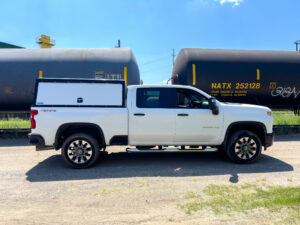 White work truck with an upfitted cap.