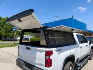Truck with the truck cap door lifted to see the shelves.