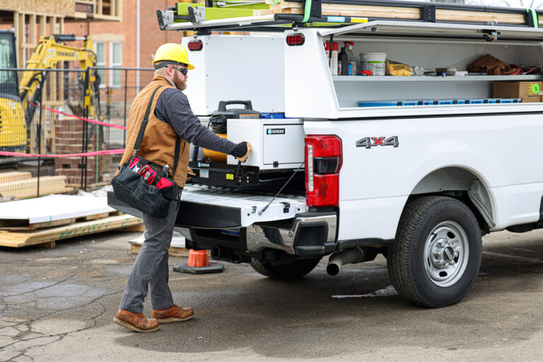 Worker walking up next to work truck
