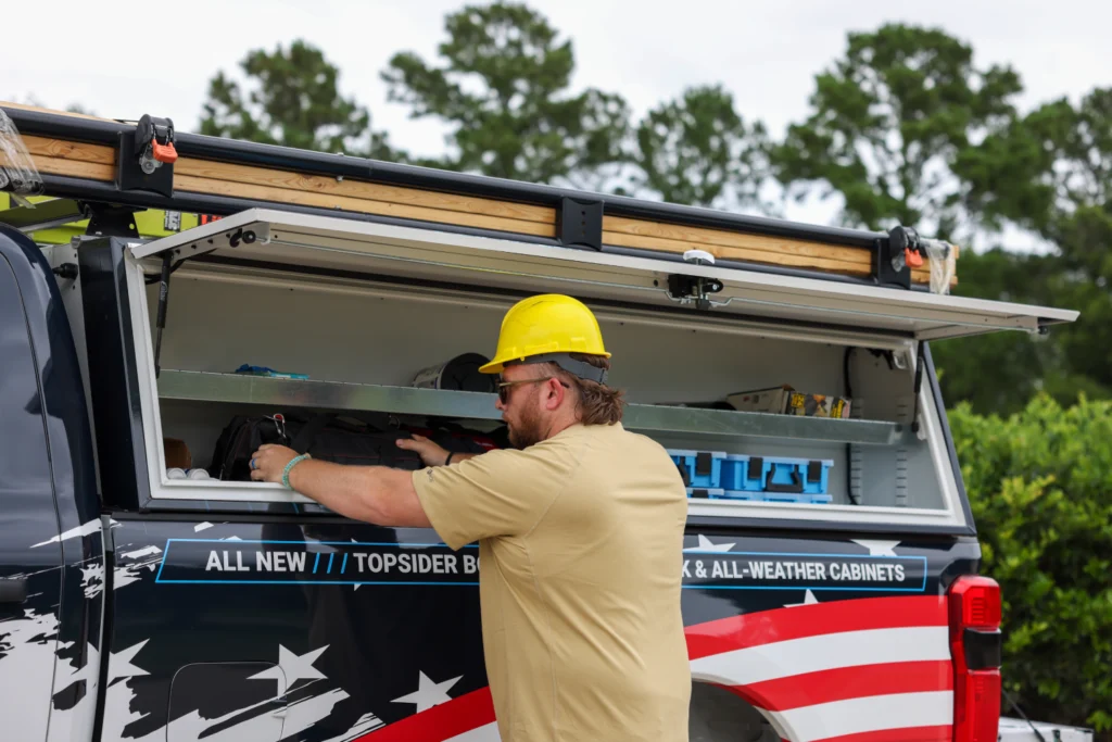 Worker getting tools from an Adrian upfitted truck bed