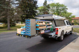 Work truck with a slide out truck bed storage system