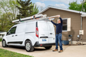 A plumber putting pipes onto his Adrian ladder rack.